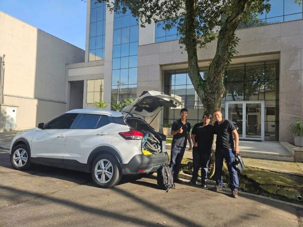 Equipe da Sérvi Z Zamerim Serviços reunida em frente a um edifício, ao lado do veículo de atendimento